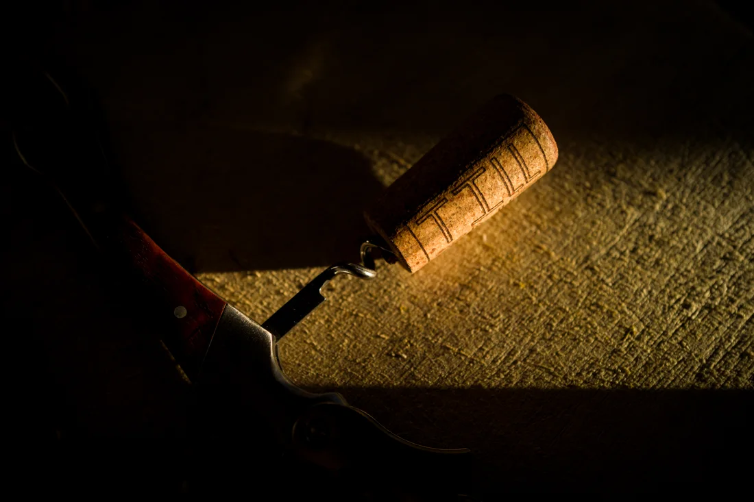 A cork and corkscrew in warm sunlight