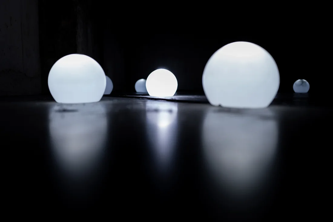 Glowing spheres reflected on a dark floor